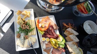 Eine Auswahl an Käse, Wurst und Gemüse auf einem Tisch.