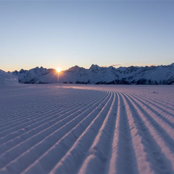 Eine wunderschöne schneebedeckte Landschaft bei Sonnenaufgang.