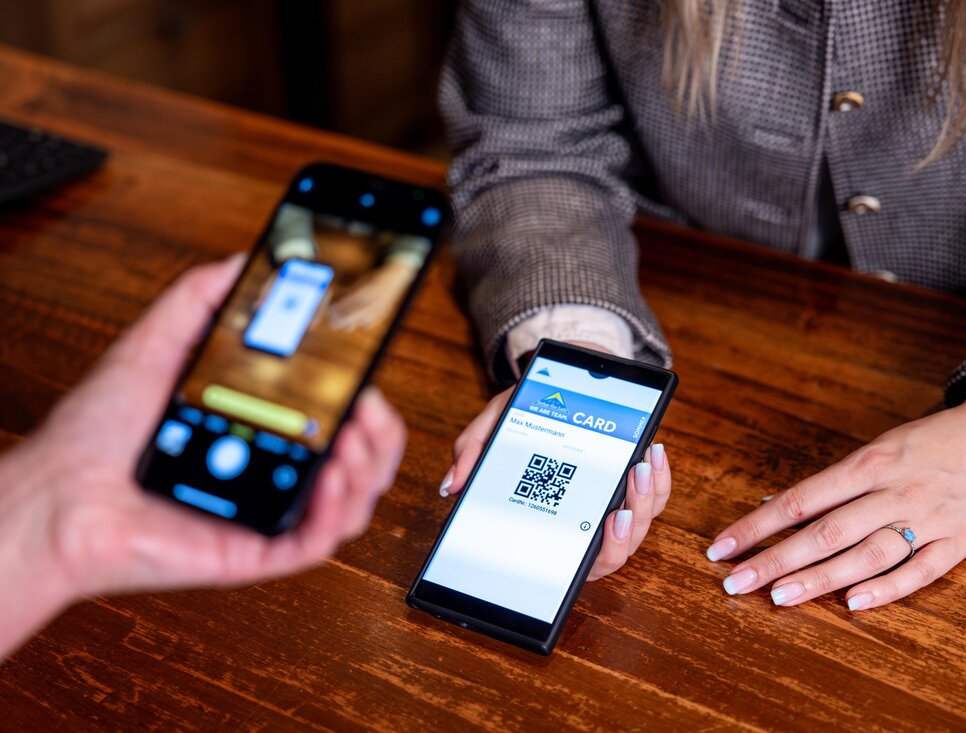 A person scans a QR code on a smartphone for payment.