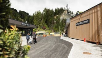 Der Check-in-Bereich zur Komperdellbahn in einer bergigen Umgebung.