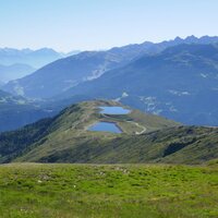 Blick auf eine Gebirgslandschaft mit zwei Wasserbecken von oben.