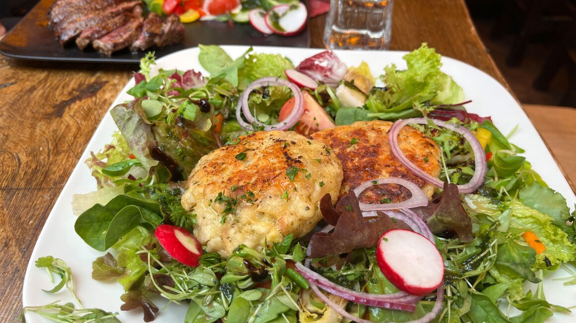 Leckerer Salat mit Fischfrikadellen und Radieschen.