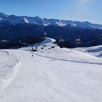 Blick auf Piste 106 im Skigebiet mit Bergkulisse.