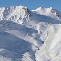 Panoramablick auf schneebedeckte Berge und Pisten.