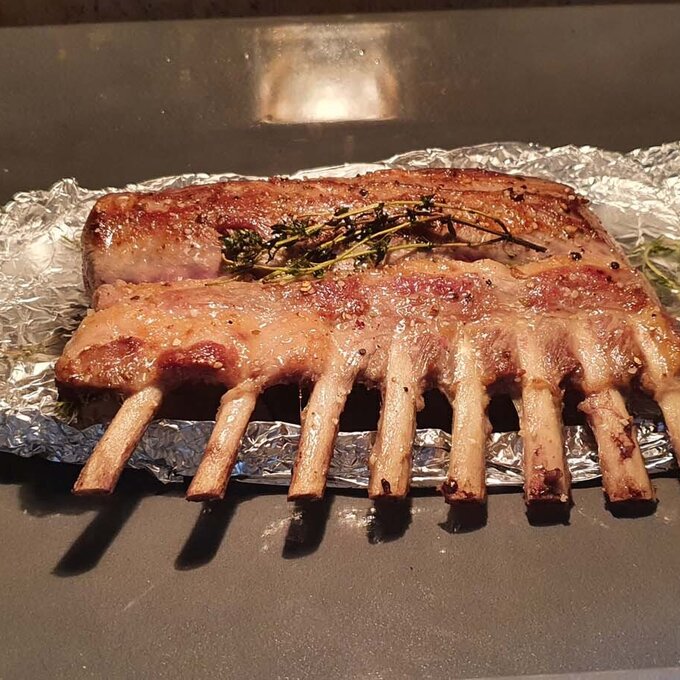 Lammrippen auf Folie im Ofen mit Kräutern garen.