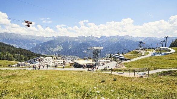 Sonniger Tag in den Bergen mit Seilbahn und Wanderern.