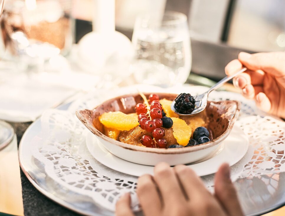 Ein köstliches Fruchtdessert mit Beeren und Zitrusfrüchten auf einem eleganten Tisch.