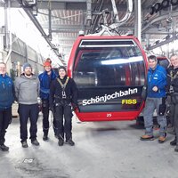 Fünf Personen stehen vor der Schönjochbahn-Seilbahn in Fiss.