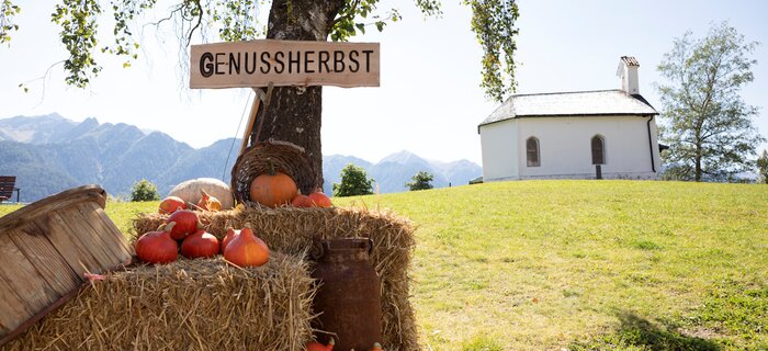 Kürbisse und Heuhaufen mit Schildern im Genussherbst.