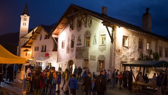 Menschen versammeln sich nachts in einem österreichischen Dorf.