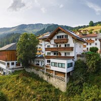Ein familiär geführtes, charmantes Haus in mitten der Serfauser Bergwelt mit bester Aussicht, in ruhiger Lage. Umgeben von grünen Wiesen, Bäumen und anderen Gebäuden.