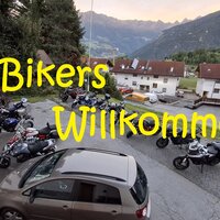 Eine Gruppe von Motorrädern parkt vor unserer Pension in den Bergen. Die Begrüßung für Biker ist deutlich sichtbar.